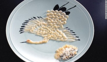 Cá nóc được thái thành lát trong suốt đặt trên đĩa sứ có hoa văn