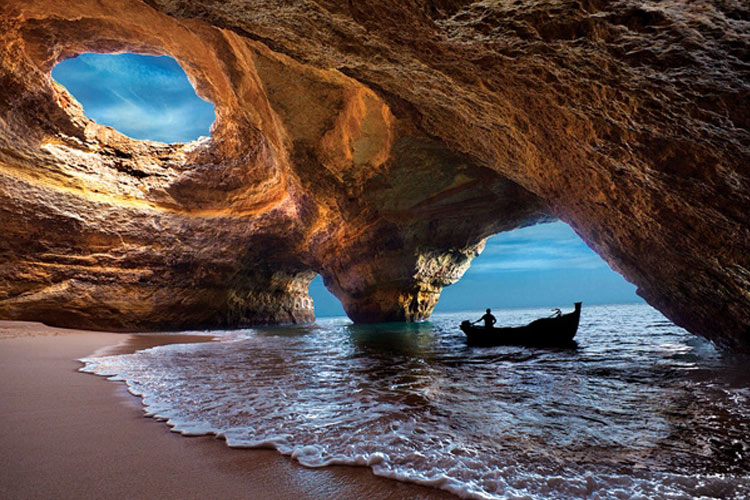 Hang biển Benagil, Algarve, Bồ Đào Nha: Du khách có thể thư giãn trên bãi biển mà không lo bị cháy nắng khi tới hang động lạ lùng này trên bờ biển Algarve của Bồ Đào Nha. Ngoài những mái vòm tự nhiên lộng lẫy, ánh mặt trời còn phản chiếu từ tường đá, đem lại cho mặt nước màu xanh huyền ảo.